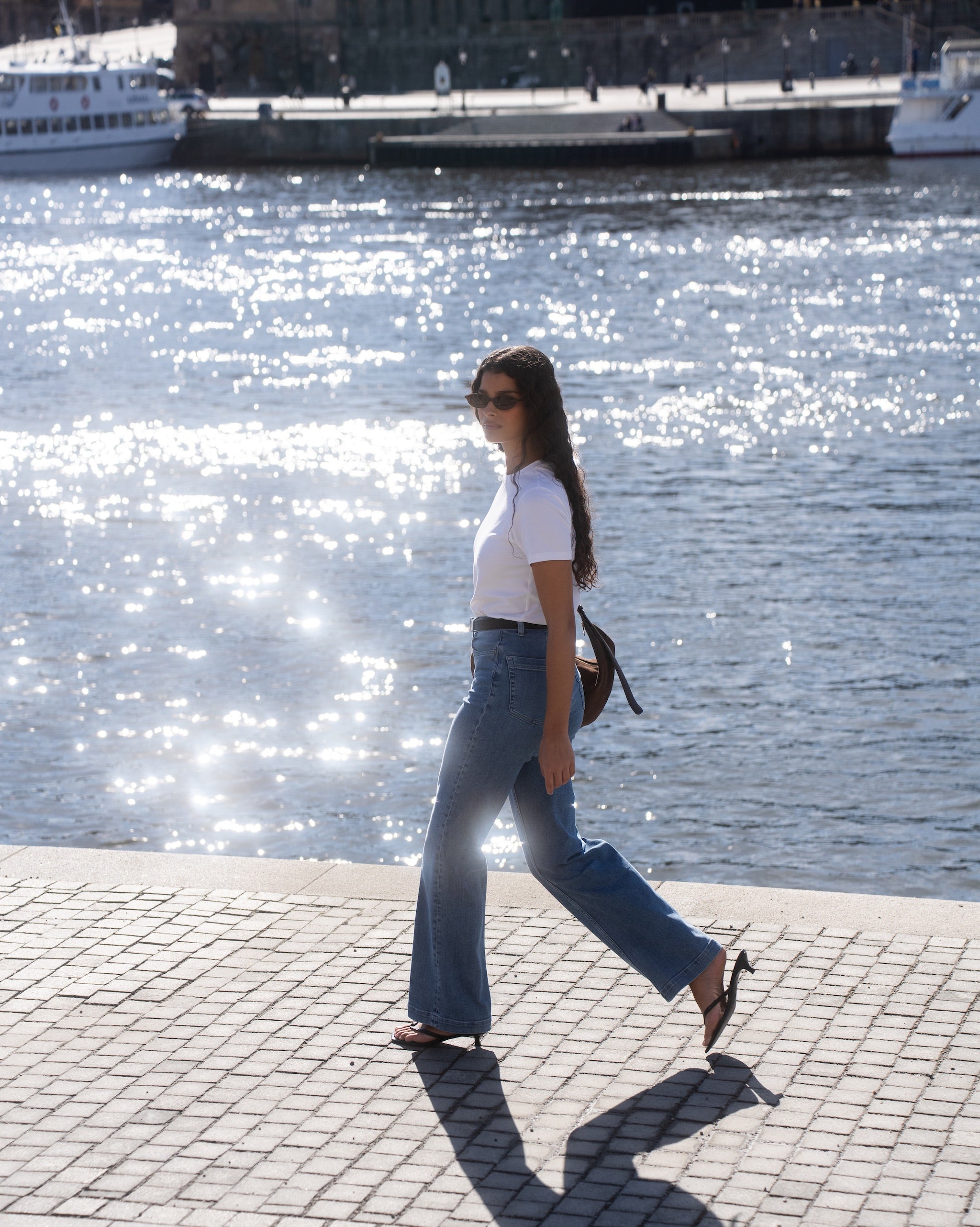 A woman wearing a white fitted Pima T-shirt styled with Ninepine Summer ComfortDenim jeans for a clean minimalist outfit.